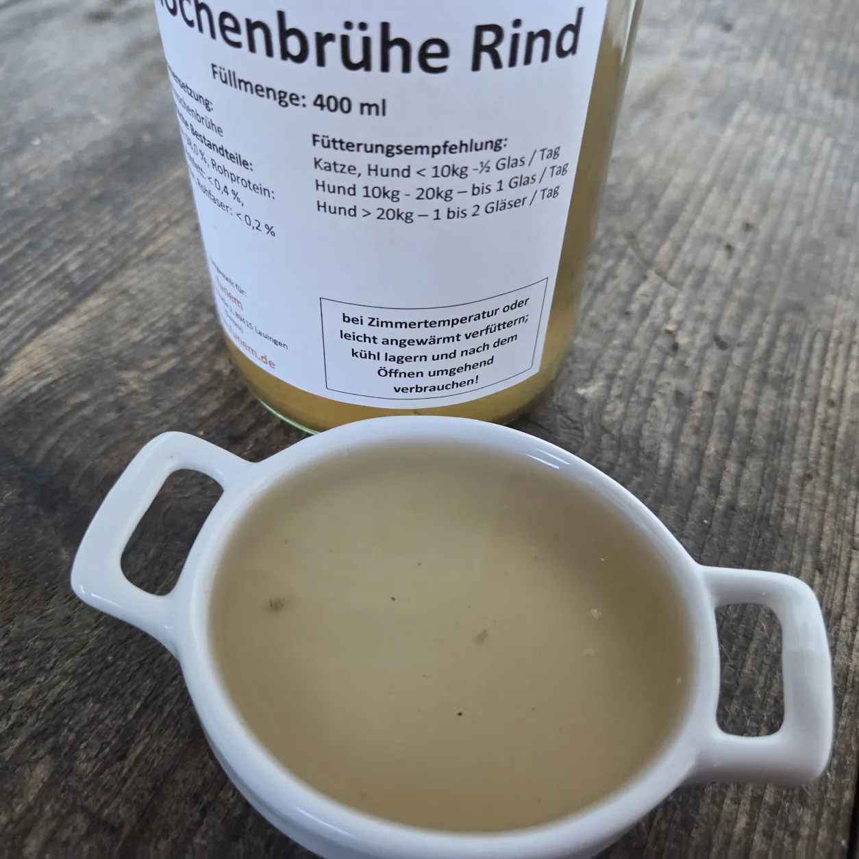 Knochenbrühe Rind in einer Schüssel mit dem Produktglas von funem im Hintergrund