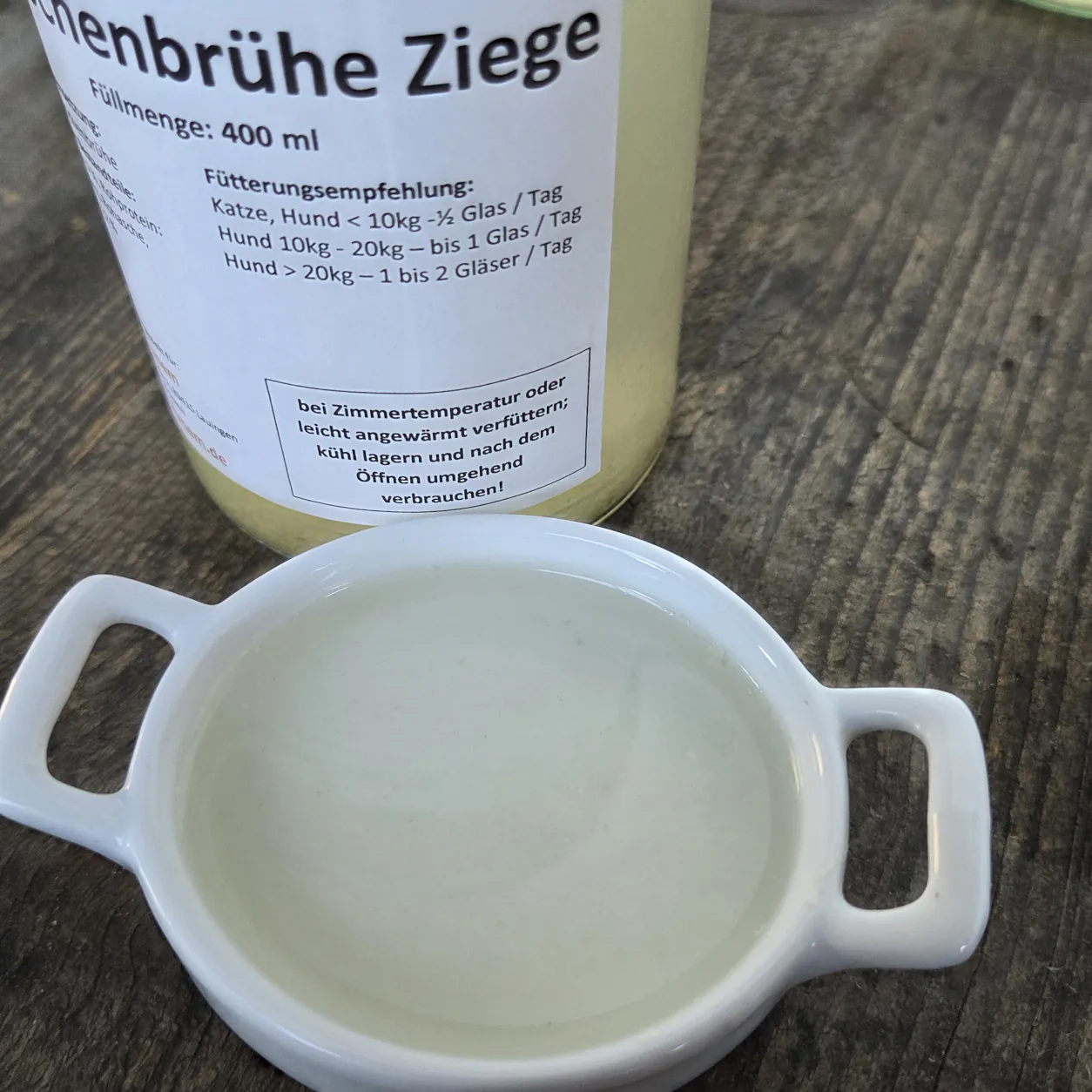 Knochenbrühe Ziege in einer Schüssel mit dem Produktglas von funem im Hintergrund