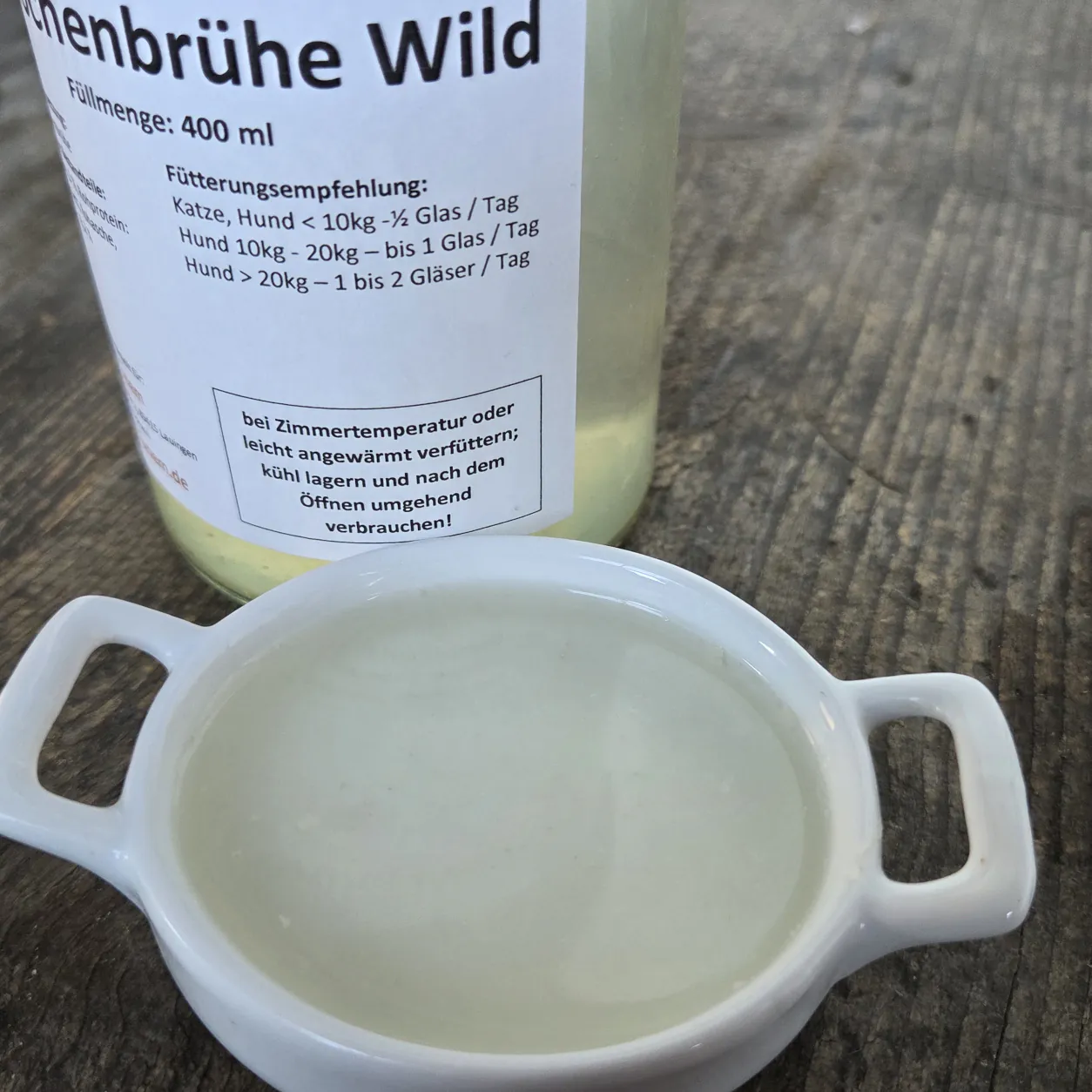 Knochenbrühe Wild in einer Schüssel mit dem Produktglas von funem im Hintergrund