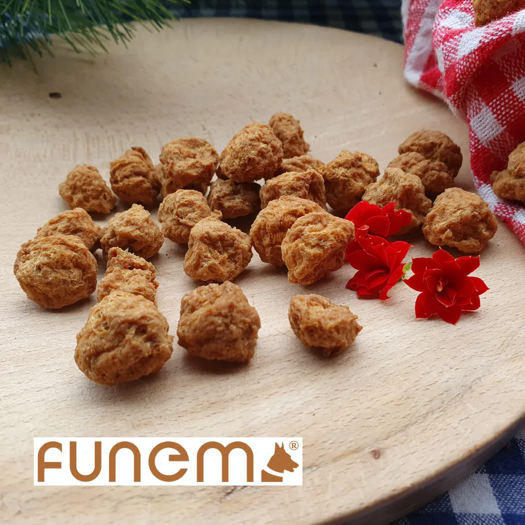 Klassisch getrocknete Leckerlis für Hunde von funem – natürliche, knusprige Fleischstücke auf Holzbrett mit roten Blüten